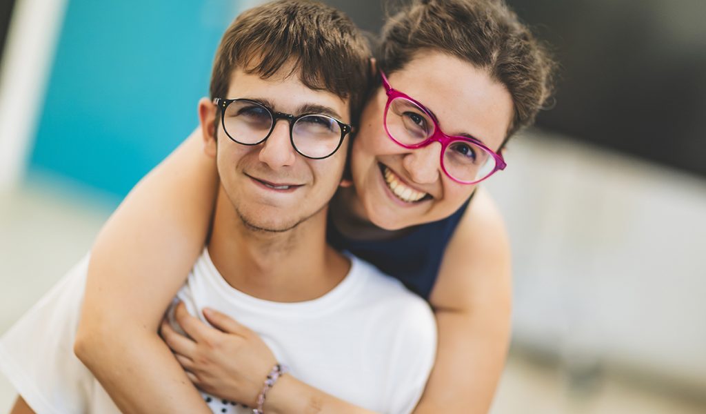 Un utente del Centro Tiresia e una operatrice si abbracciano sorridenti